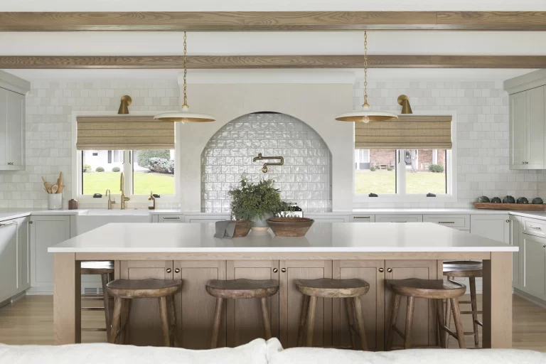 Kitchen with large center island, stove with decorative arched wall above and tile walls