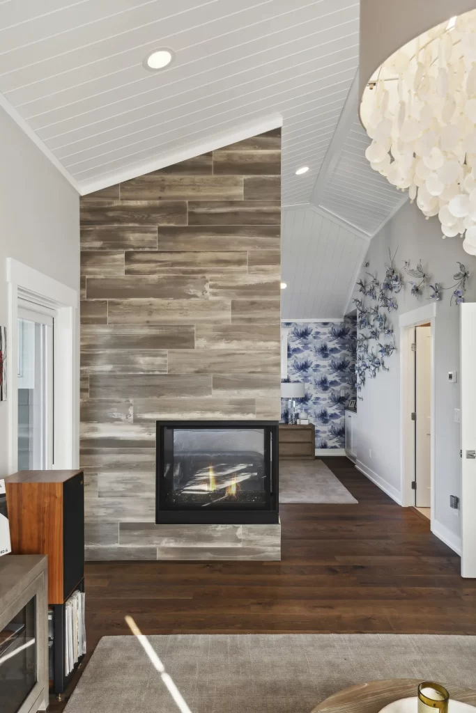 view of fireplace wall that separates master bedroom sitting area from master bedroom with a view of blue wallpaper