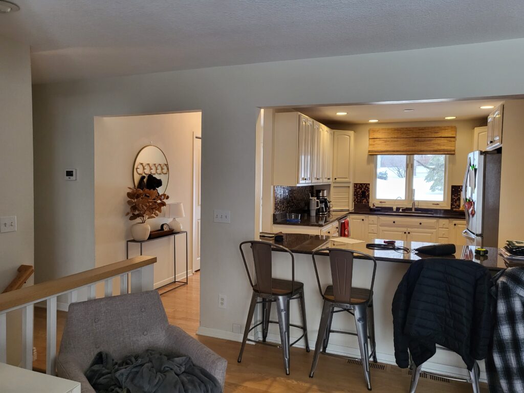 view of a kitchen with stools in front of it